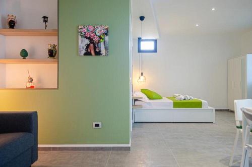 a room with a bed with a green wall at Sunrise Luxury Apartments in Cassibile