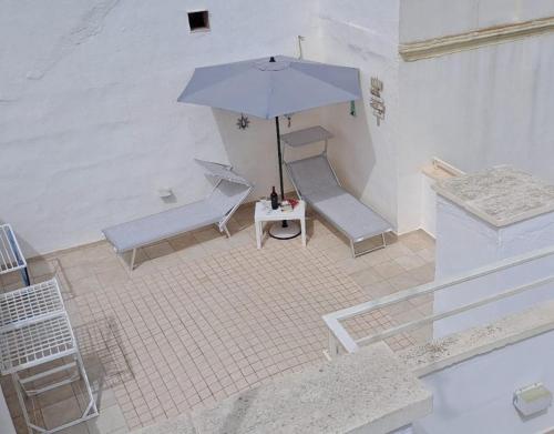 an overhead view of a patio with a table and an umbrella at Cinque terrazze - Casa d'epoca con vista mare in Gallipoli