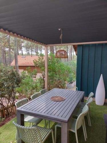 une table et des chaises en bois sur une terrasse dans l'établissement La_pinede_lacanau_ocean, à Lacanau-Océan