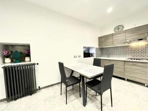 una cucina con un tavolo e sedie in una stanza di Nel Cuore di Palermo Isidoro Palace a Palermo
