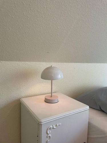 a table with a lamp on top of a dresser at Homestay in charming house on the countryside in Rønne