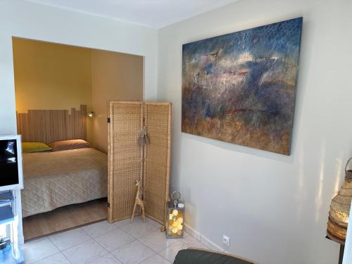 une chambre avec un lit et un tableau au mur dans l'établissement 7Appt, TERRASSE ,Vélo , Plages & port à proximité , idéalement bien Situé, Dernier étage, à La Baule