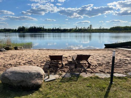 twee stoelen op een strand naast een meer bij Mäeküla Järve Palkmaja in Viljandi