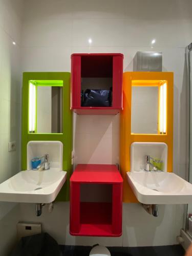 une salle de bain avec deux lavabos et deux miroirs dans l'établissement Appartement Haussmannien, à Charenton-le-Pont