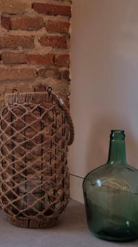 a green vase sitting next to a brick wall at Antiquari de Blanes Apartamento Boutique en la Costa Brava in Blanes