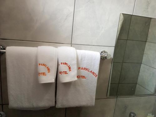Un baño con toallas blancas con letreros de béisbol. en Fourth Parklands Hotel, en Nairobi