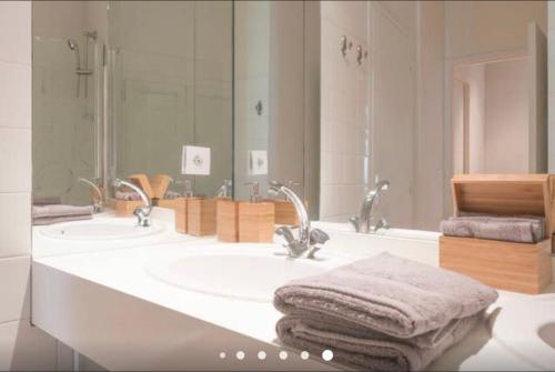 une salle de bain avec deux lavabos et un grand miroir dans l'établissement Capitole - Centre ville, à Toulouse