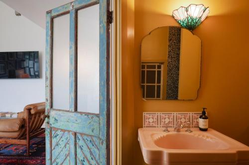 a bathroom with a sink and a mirror at Molly's Cabin, Countryside Stay in Sutton Bonington