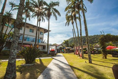 a group of palm trees in front of a building at Hotel VillaReal Guaratuba - Caieiras in Guaratuba