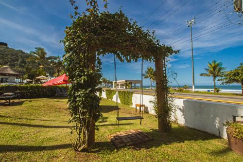 ein Park mit Bäumen und einer Bank im Gras in der Unterkunft Hotel Villareal Guaratuba - Caieiras in Guaratuba