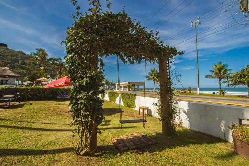 a park with trees and a bench in the grass at Hotel VillaReal Guaratuba - Caieiras in Guaratuba