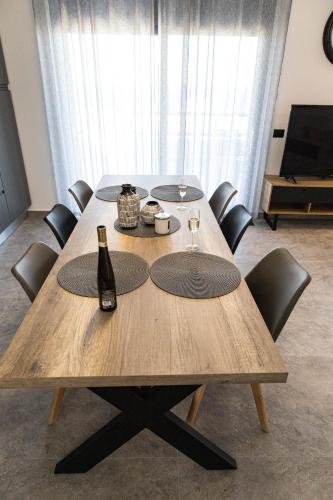 a table with chairs and a bottle of wine on it at Aegeans Eye in Azolimnos