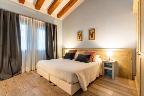 una camera con un grande letto e una finestra di ACCADEMIA VINE LODGE a Capriva del Friuli