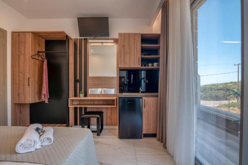 a room with a kitchen with a bed and a window at Xasteria in Elafonisi