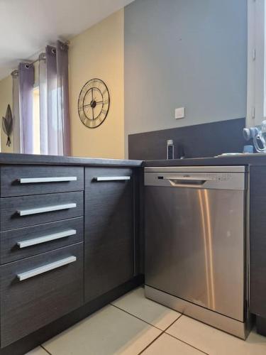 a kitchen with a stainless steel dishwasher and a sink at Maison familiale in Podensac