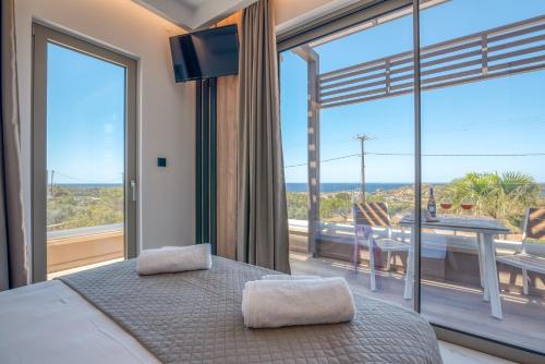 a bedroom with a bed and a large window at Xasteria in Elafonisi