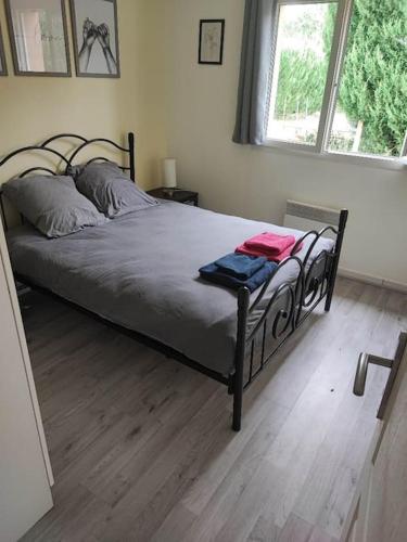 a bed in a bedroom with a wooden floor at Maison familiale in Podensac