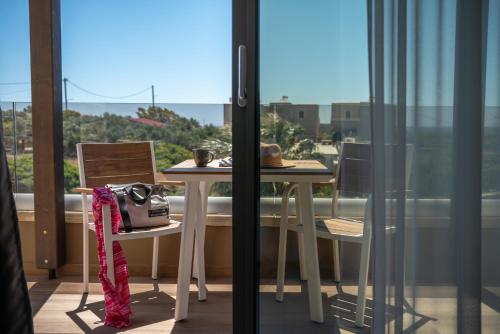 a balcony with a table and chairs and a window at Xasteria in Elafonisi