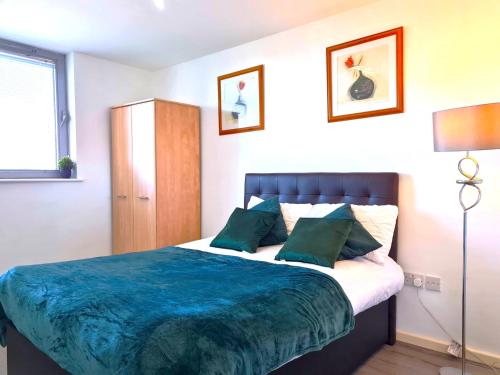a bedroom with a large bed with green pillows at Central Retreat- A Cosy 2 Bedroom Flat with View in L3 in Liverpool