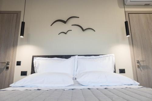 a bedroom with a bed with two birds on the wall at Aegeans Eye in Azolimnos