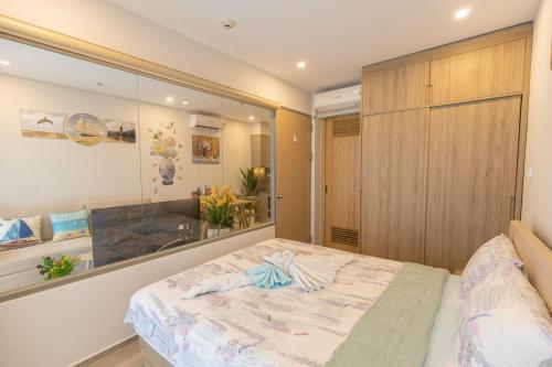 a bedroom with a large bed and a glass wall at The Sóng Vũng Tàu Homestay - Suri's Apartment in Vung Tau