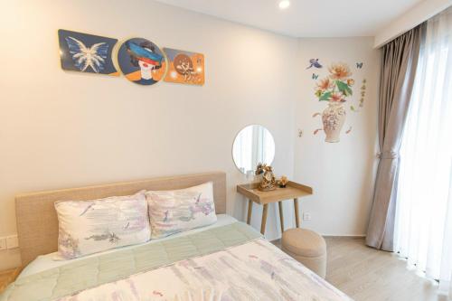a bedroom with a bed and some pictures on the wall at The Sóng Vũng Tàu Homestay - Suri's Apartment in Vung Tau