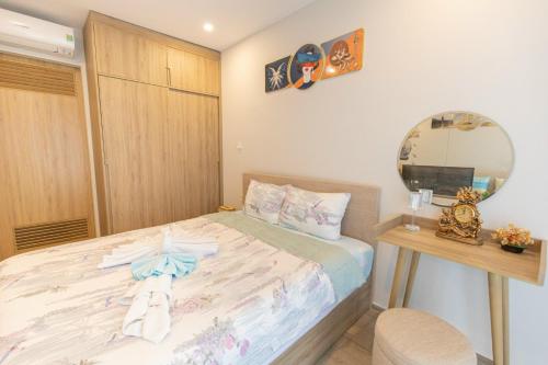 a small bedroom with a bed and a mirror at The Sóng Vũng Tàu Homestay - Suri's Apartment in Vung Tau