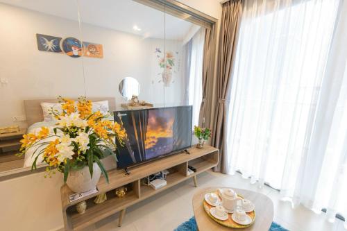 a living room with a tv and a large window at The Sóng Vũng Tàu Homestay - Suri's Apartment in Vung Tau