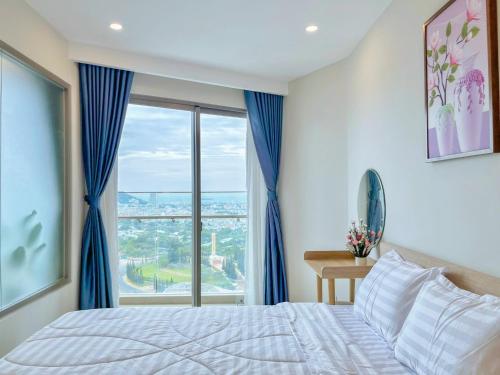 a bedroom with a bed and a large window at The Sóng Vũng Tàu Homestay - Suri's Apartment in Vung Tau