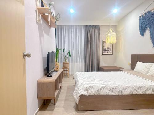 a hotel room with two beds and a television at The Sóng Vũng Tàu Homestay - Suri's Apartment in Vung Tau