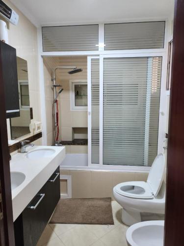 a bathroom with a toilet and a sink and a tub at Villa Cap Spartel Tanger Achakkar FAMILY ONLY in Jebila