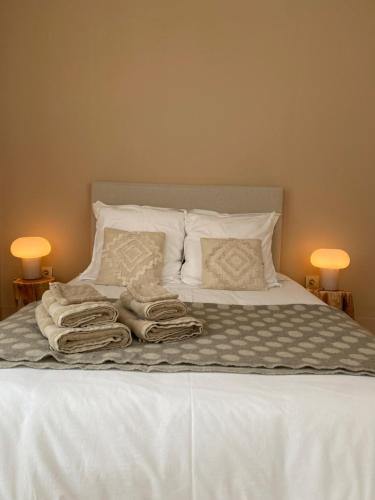 Una cama con sábanas blancas y toallas. en Les chambres de la Villa Oberlin, en Beblenheim