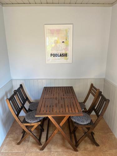 a wooden table and two chairs in a room at Siedlisko Glinnik in Glinnik