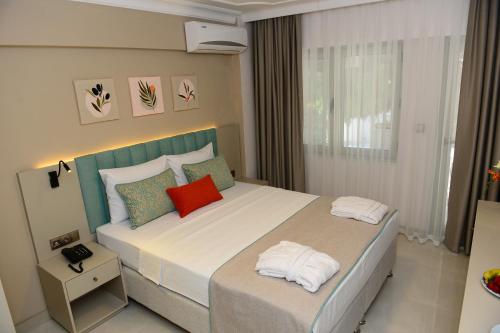 a bedroom with a large bed with two pillows at ROSE GARDEN PREMIUM in Antalya
