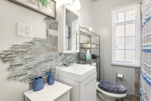 a bathroom with a sink and a toilet and a mirror at Comfy Modern and Cozy Queen Beds Free Parking in Detroit