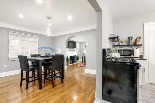 a kitchen and dining room with a black table and chairs at Comfy Modern and Cozy Queen Beds Free Parking in Detroit