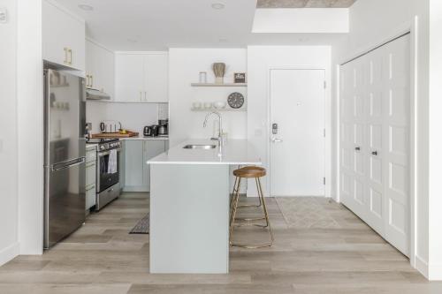 a white kitchen with a sink and a counter at Northeka208 in Quebec City