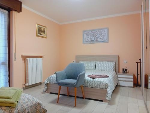 1 dormitorio con 1 cama y 1 silla azul en Casa Vacanze Kristina, en Brissago Valtravaglia