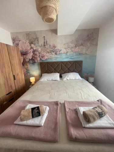 a bedroom with a large bed with two towels on it at Goldy in Neum