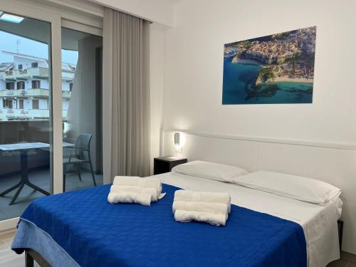 ein Schlafzimmer mit einem blauen Bett und Handtüchern darauf in der Unterkunft B&B Albachiara in Tropea
