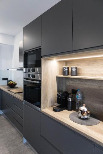 a kitchen with black cabinets and a counter top at Aegeans Eye in Azolimnos