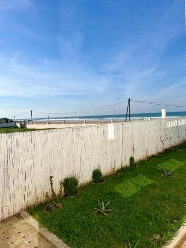 a fence on the beach with the ocean in the background at Dar Zouina 1 et 2 in Briech