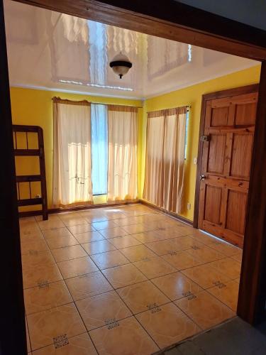 an empty room with yellow walls and a tiled floor at Casa Tahoe Home Stay Playa Pita, Costa Rica in Tarcoles