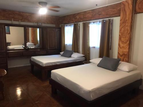 a bedroom with two beds and a mirror at Casa Tahoe Home Stay Playa Pita, Costa Rica in Tarcoles