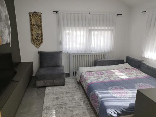 sypialnia z łóżkiem i krzesłem w obiekcie apartman HAJLA w mieście Rožaje