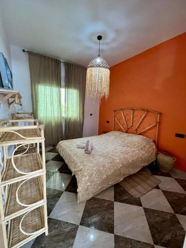 a bedroom with a large bed and a chandelier at Dar Zouina 1 et 2 in Briech