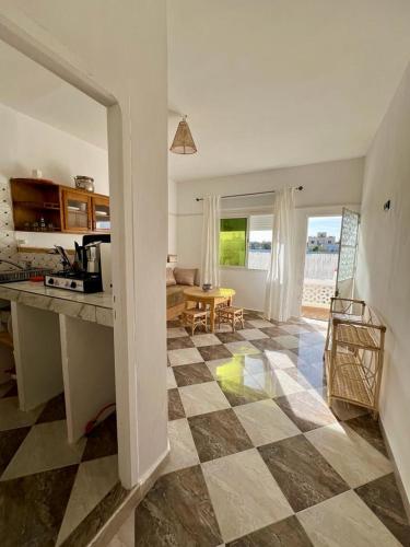 a kitchen and living room with a checkered floor at Dar Zouina 1 et 2 in Briech