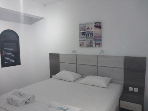 a bedroom with a white bed with two pillows at Tassos 2 in Pefkohori