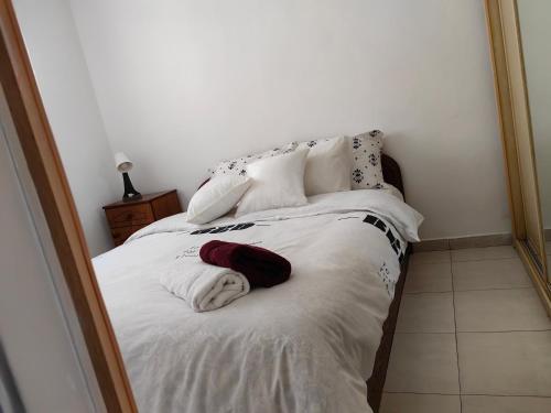 a bedroom with a bed with white sheets and pillows at near the sea even 14 days won't feel enough in Bat Yam