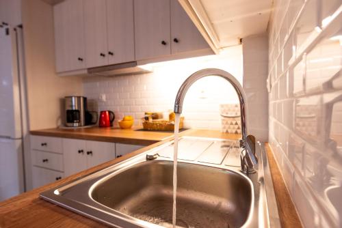 a kitchen sink with water coming out of it at Serenity - Brand New Apt Near Athens Int Arpt in Spata
